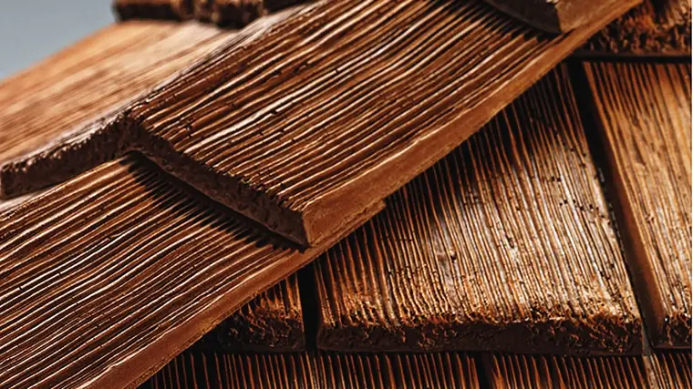 Close-up of CeDUR synthetic cedar shakes showing the deep molded grain and thick sawn butt edge