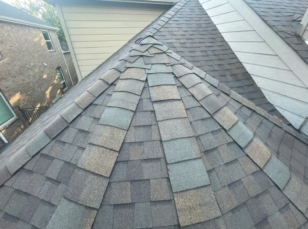 Architectural asphalt shingles installed along a hip ridge