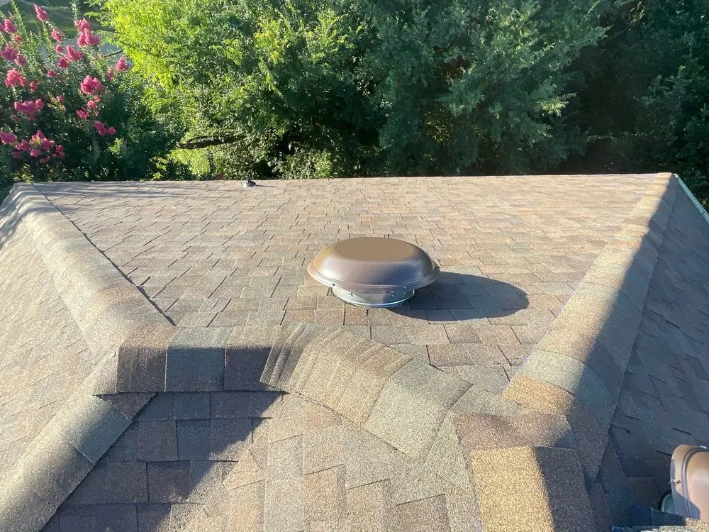 A clean asphalt shingle roof with matched shingles and a properly sealed attic vent